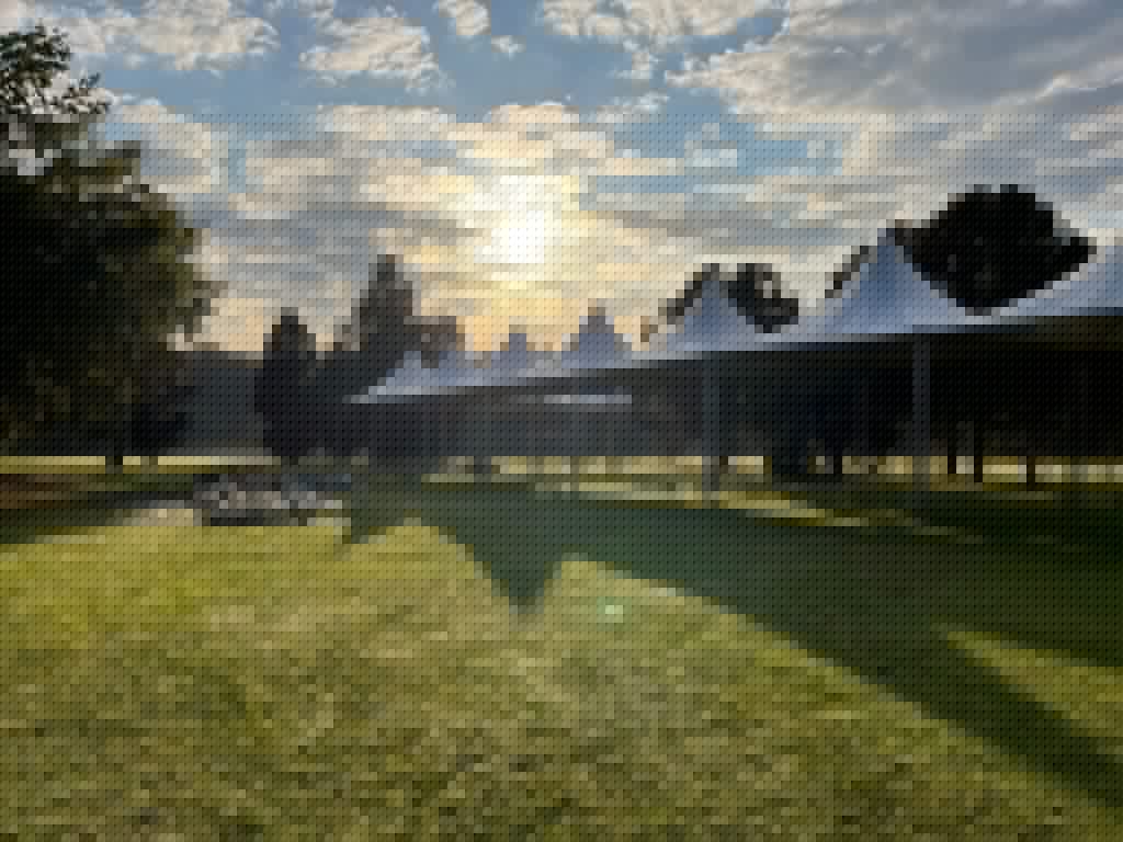 Events Guys Tents at a sunset event on a grassy field.