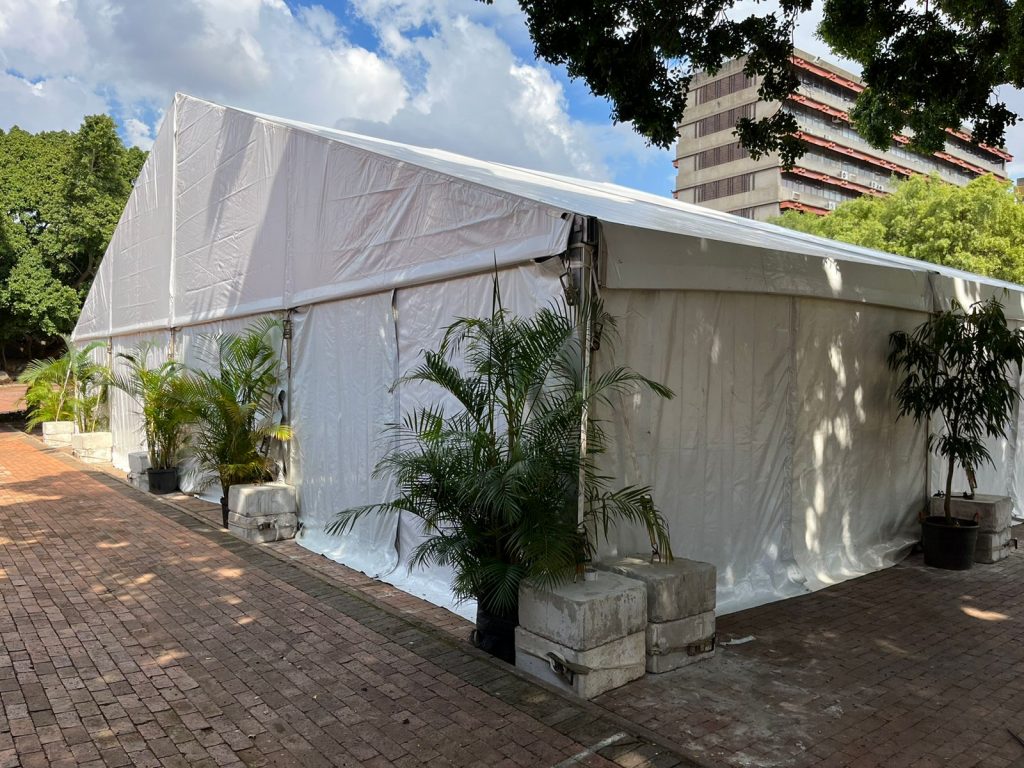 Events Guys An events tent is set up in front of a brick walkway.