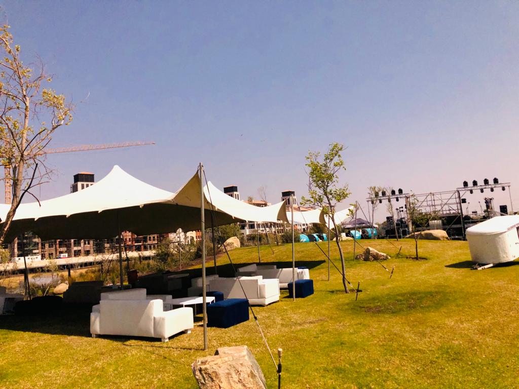 Events Guys A large tent is set up in a grassy area for events.
