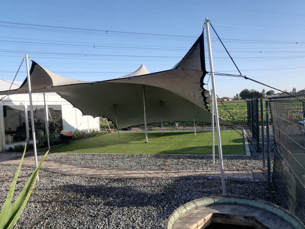 Events Guys A large tent is set up in a backyard for events.