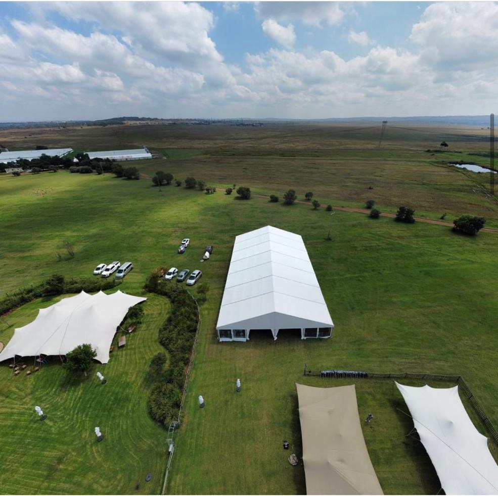 Events Guys An aerial view of a large tent set up for an event in a field.