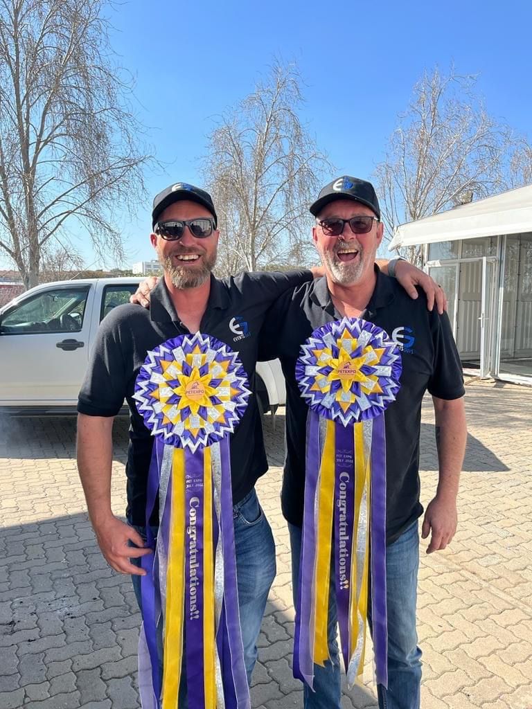 Events Guys Two men standing next to each other holding ribbons.
