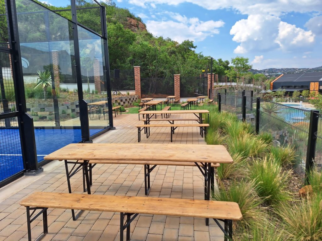 Outstanding Chair Hire Services in Your Area – The Events Guys Make Your Occasions Remarkable! 2 Events Guys A wooden table and glass coffee table on a patio near a swimming pool.