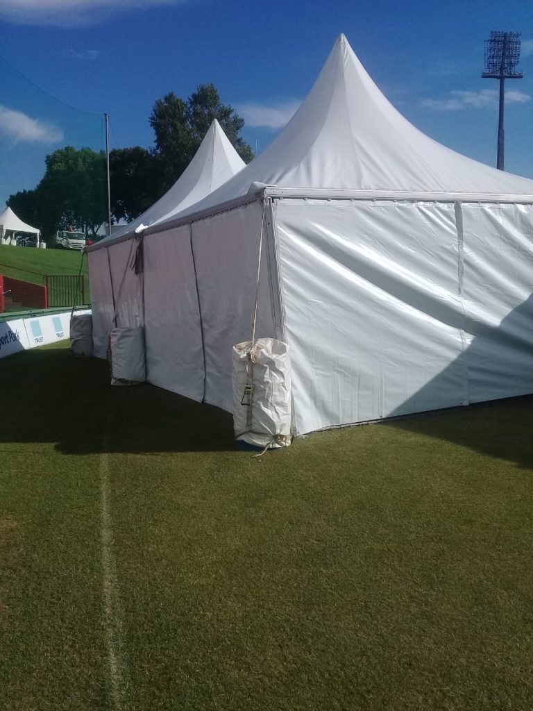 Events Guys A glass coffee table set up on a grassy field.
