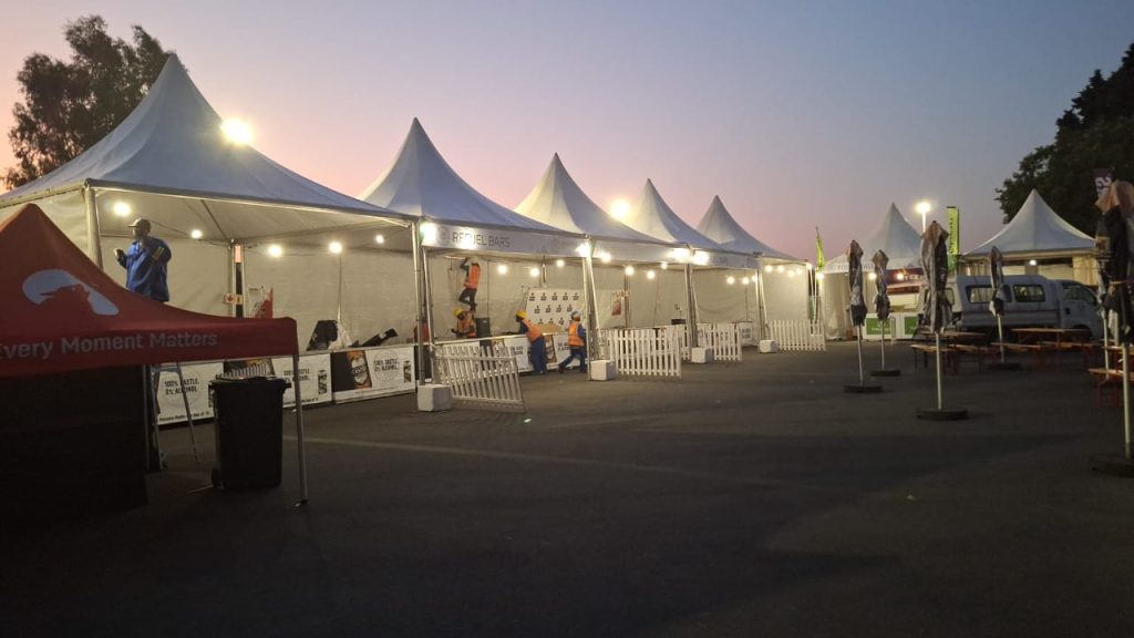 Find Quality Tents for Hire in South Africa - Simply the Best! 2 Events Guys A white tent to hire set up in a parking lot at dusk.